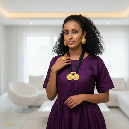 Woman in a purple dress with gold jewelry in a modern indoor setting