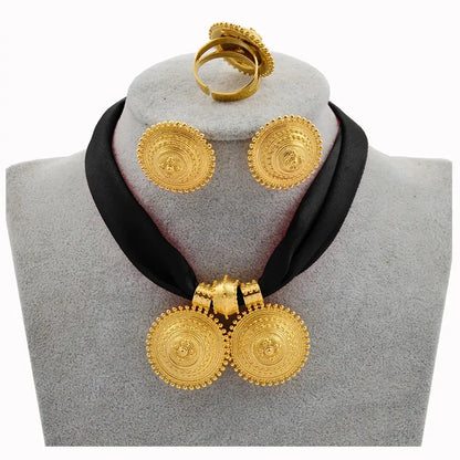 Gold necklace and earrings on a gray mannequin with a black scarf