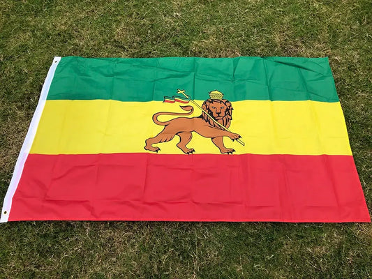 Flag with green, yellow, and red horizontal stripes featuring a lion emblem on grass.