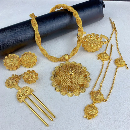 Set of gold jewelry including necklace, earrings, and ring on a white background