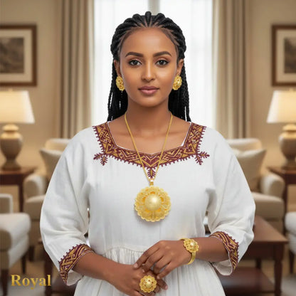 Woman in a white dress with gold embroidery and jewelry in a formal setting