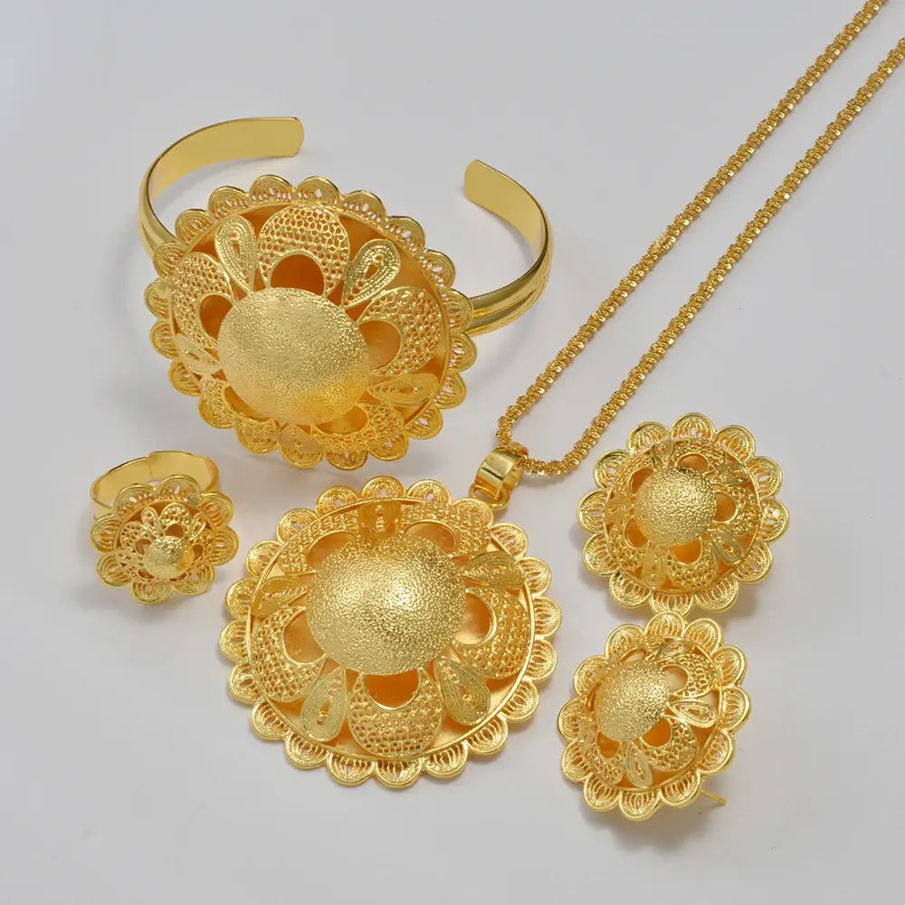 Gold jewelry set including necklace, ring, and earrings on a light gray background