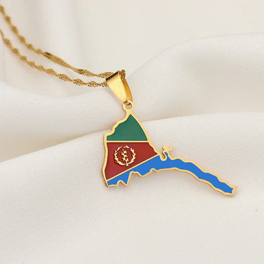 Gold pendant shaped like a map with red, green, and blue colors on a white surface