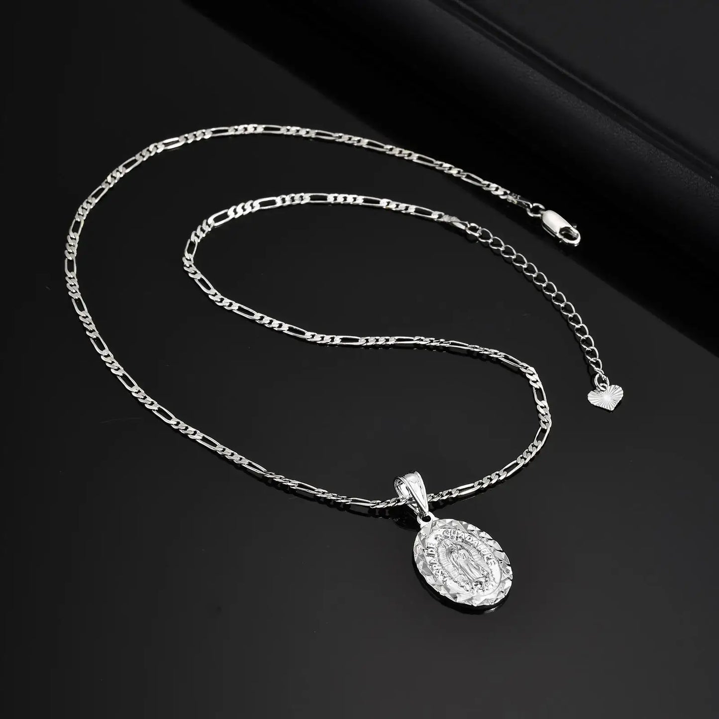 Silver chain necklace with a pendant on a black background