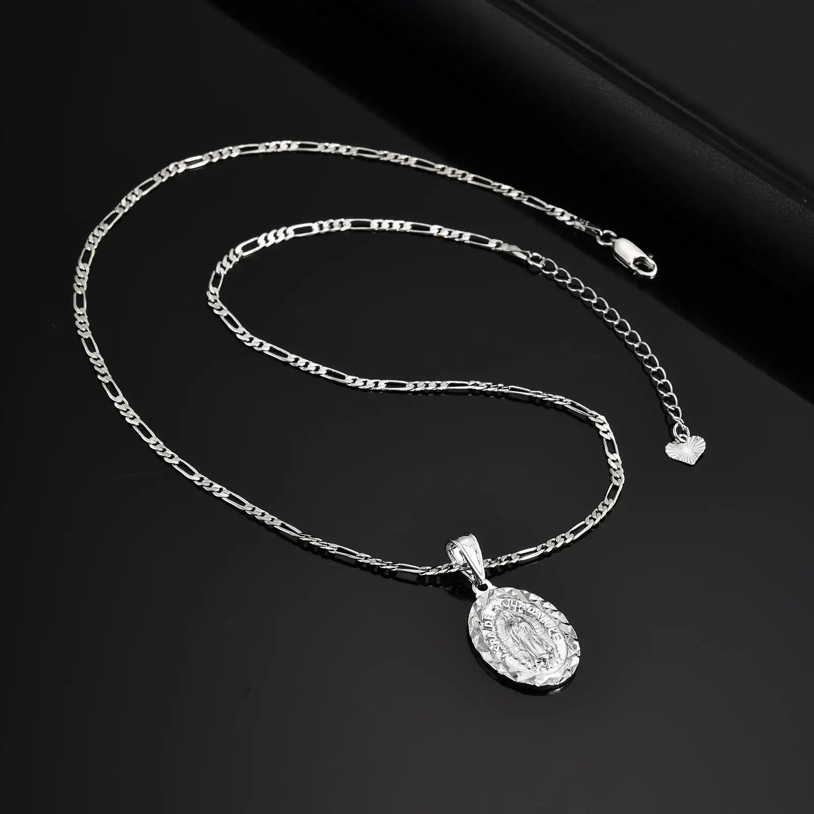 Silver chain necklace with a pendant on a black background