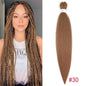 Woman with braided hair next to a bundle of brown hair extensions on a white background.