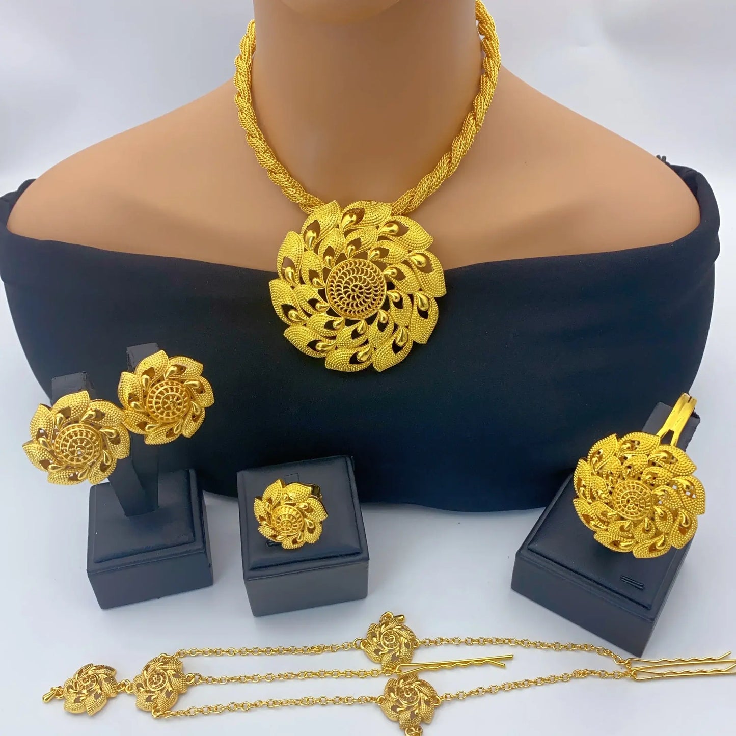 Gold jewelry set including necklace, earrings, and bracelet on a mannequin and white background.