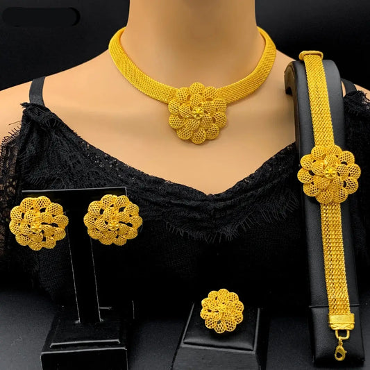 Gold jewelry set including necklace, earrings, and bracelet on a mannequin with a black top.