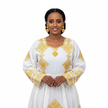 Woman wearing a white dress with gold embroidery on a white background