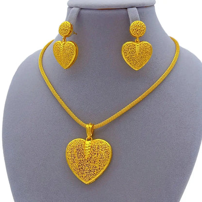 Gold heart-shaped necklace and earrings on a mannequin bust.