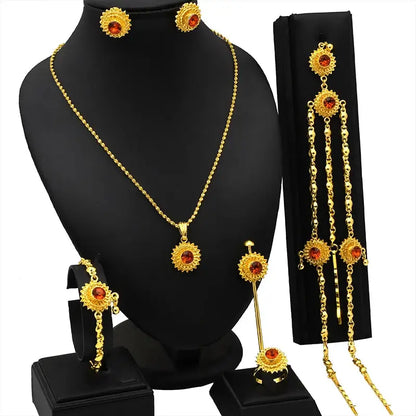 Gold jewelry set with necklace, earrings, and hair accessories on a black mannequin.