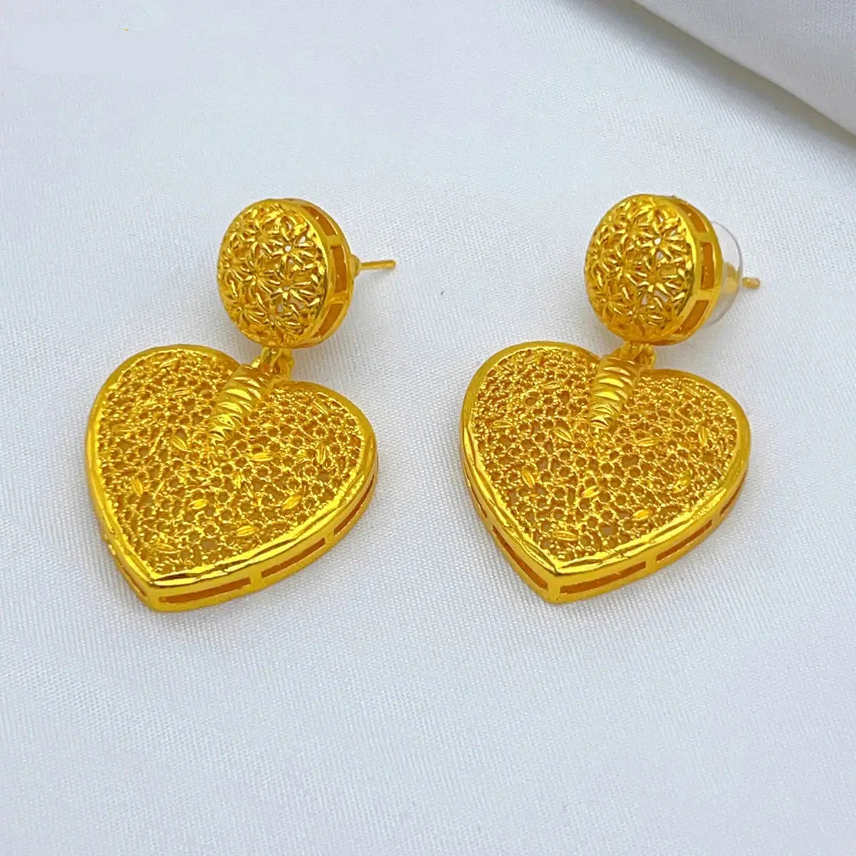 Gold heart-shaped earrings on a white background