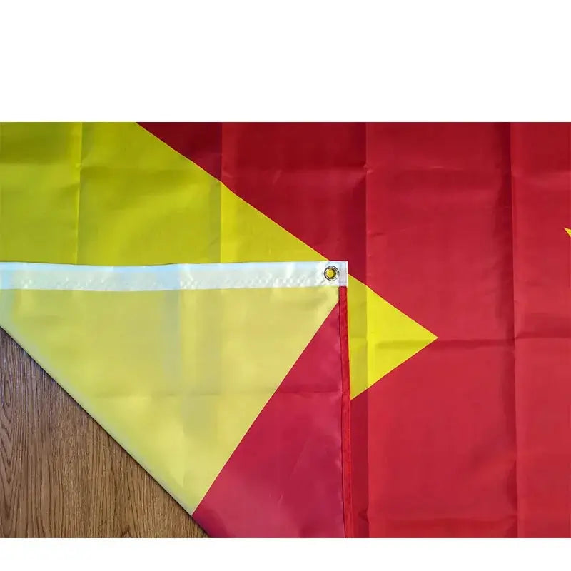 Red and yellow flag with a yellow triangle on a wooden surface