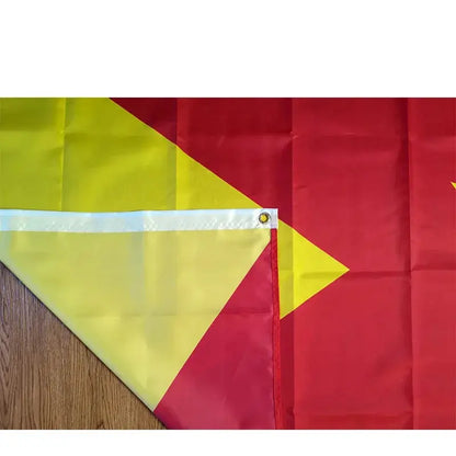 Red and yellow flag with a yellow triangle on a wooden surface