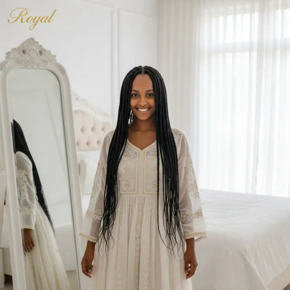 Woman in a white dress standing in front of a mirror with 'Royal' branding.