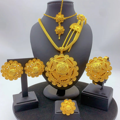 Gold jewelry set including necklace, earrings, and ring on a black stand with a white background