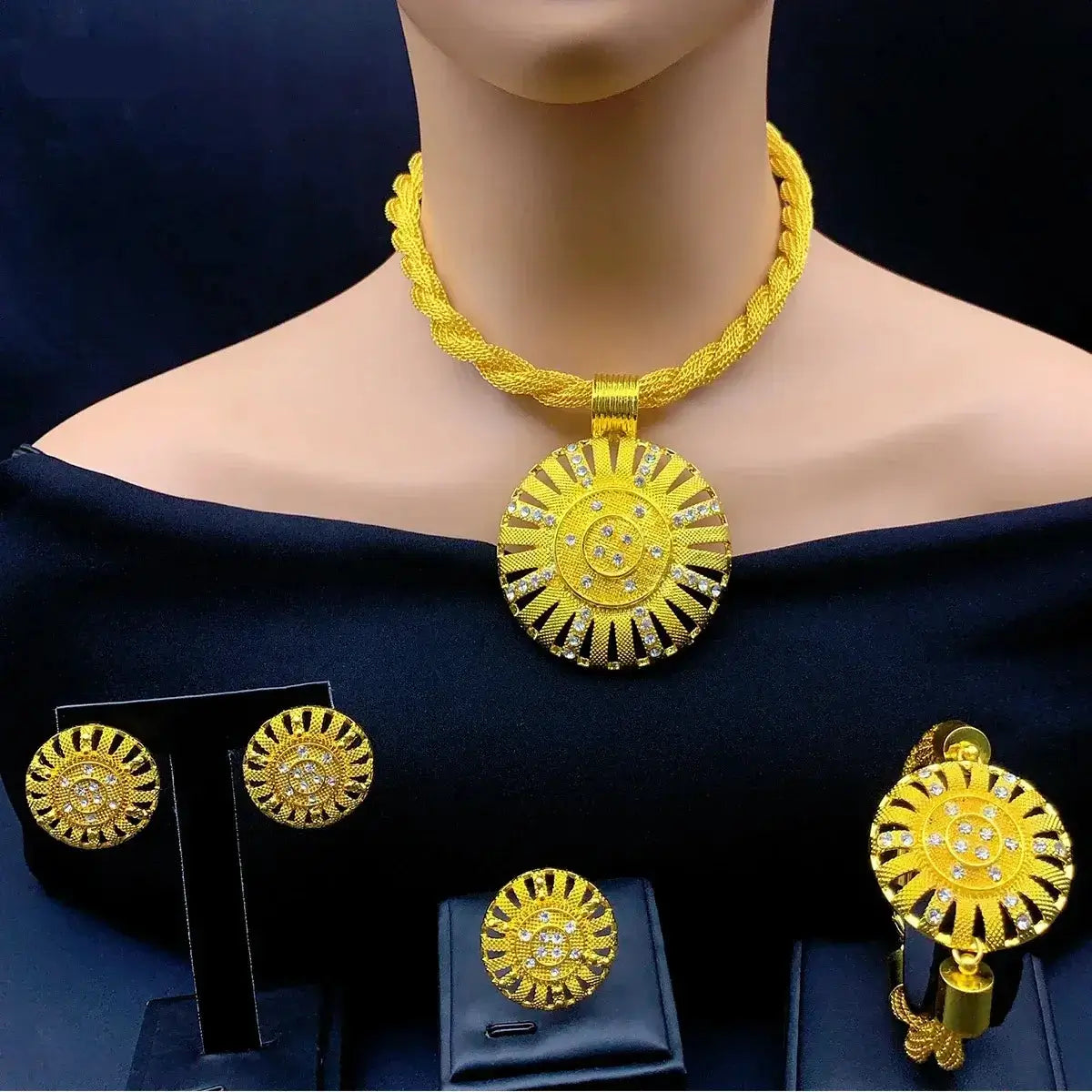 Gold necklace and earrings set on a mannequin with a dark background
