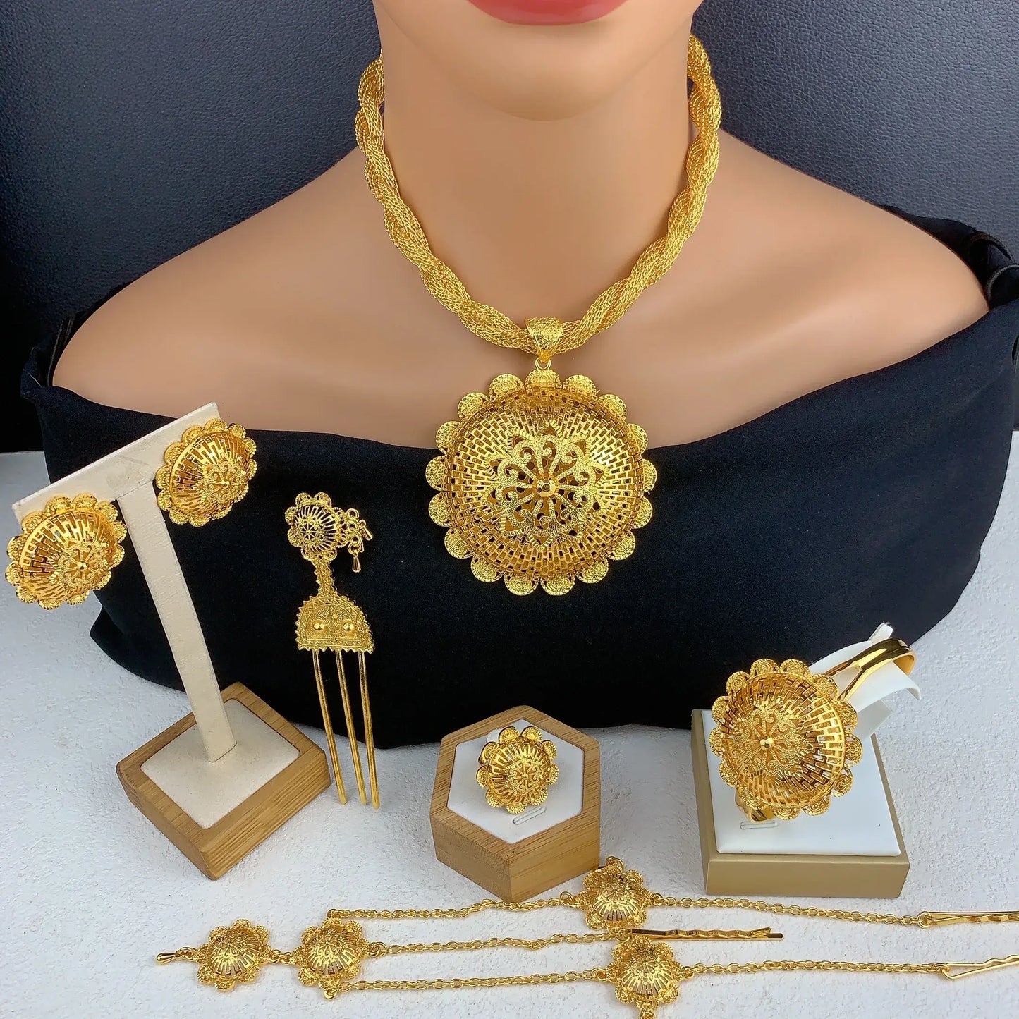Gold jewelry set including necklace, earrings, and hair accessories on a mannequin.