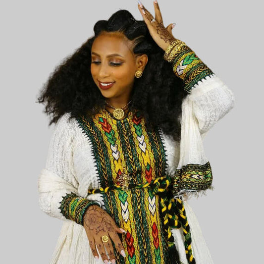Woman wearing a colorful traditional outfit with intricate patterns on a gray background